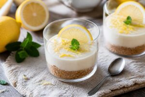 Kalte Zitronen-Tarte im Glas ohne Backen – knuspriger Keksboden mit cremiger Zitronencreme, garniert mit Zitronenzeste und frischer Minze